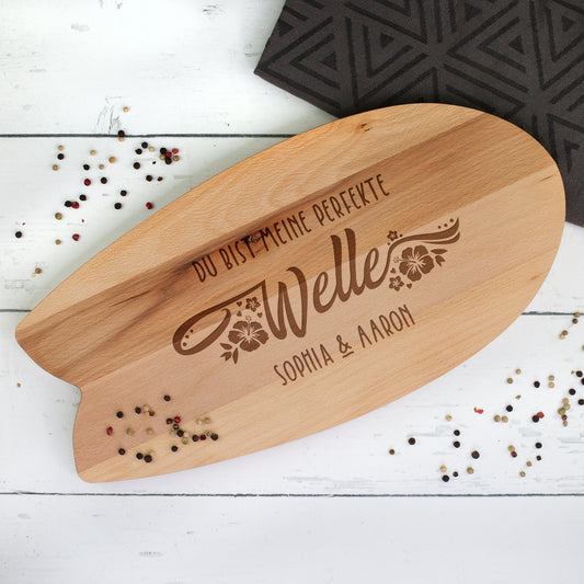 Graviertes Surfbrett-Servierbrett aus Buchenholz mit Hibiskus-Motiv und Personalisierung – liegend auf Tisch mit Gewürz und Stoffunterlage