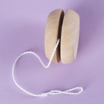 Seitenansicht des Holz-Yo-Yos mit Schnur auf lila Hintergrund