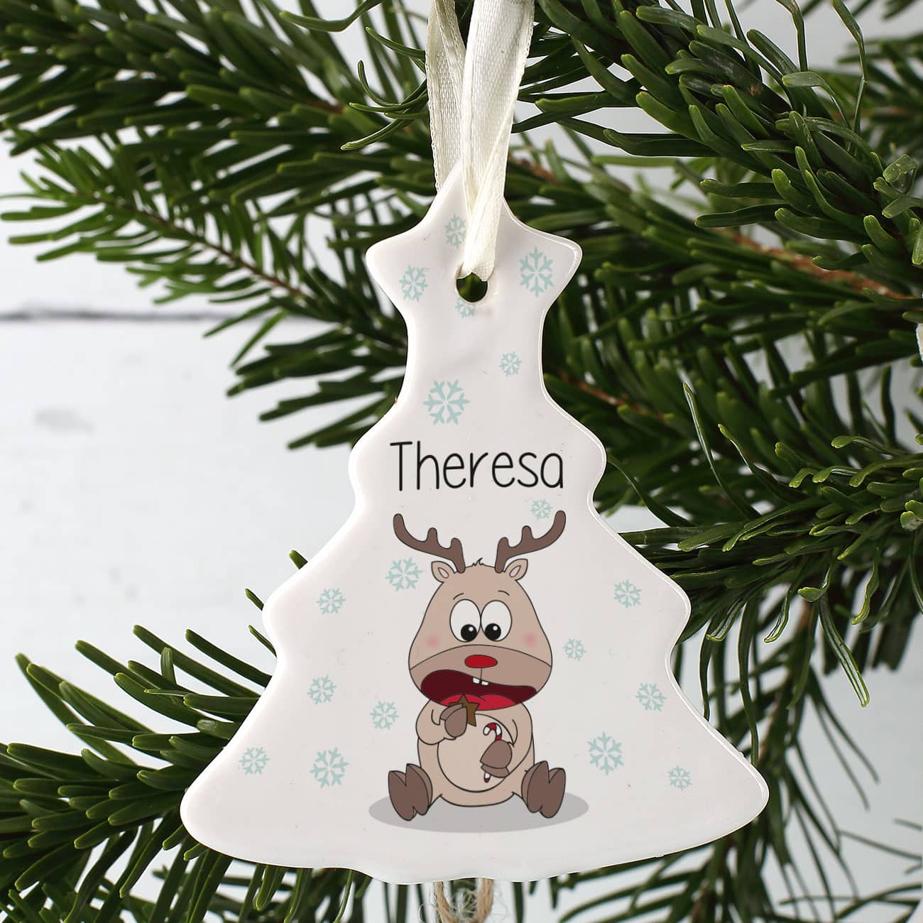 Christbaumschmuck mit Schneeflocken und niedlichen Rentier bedruckt