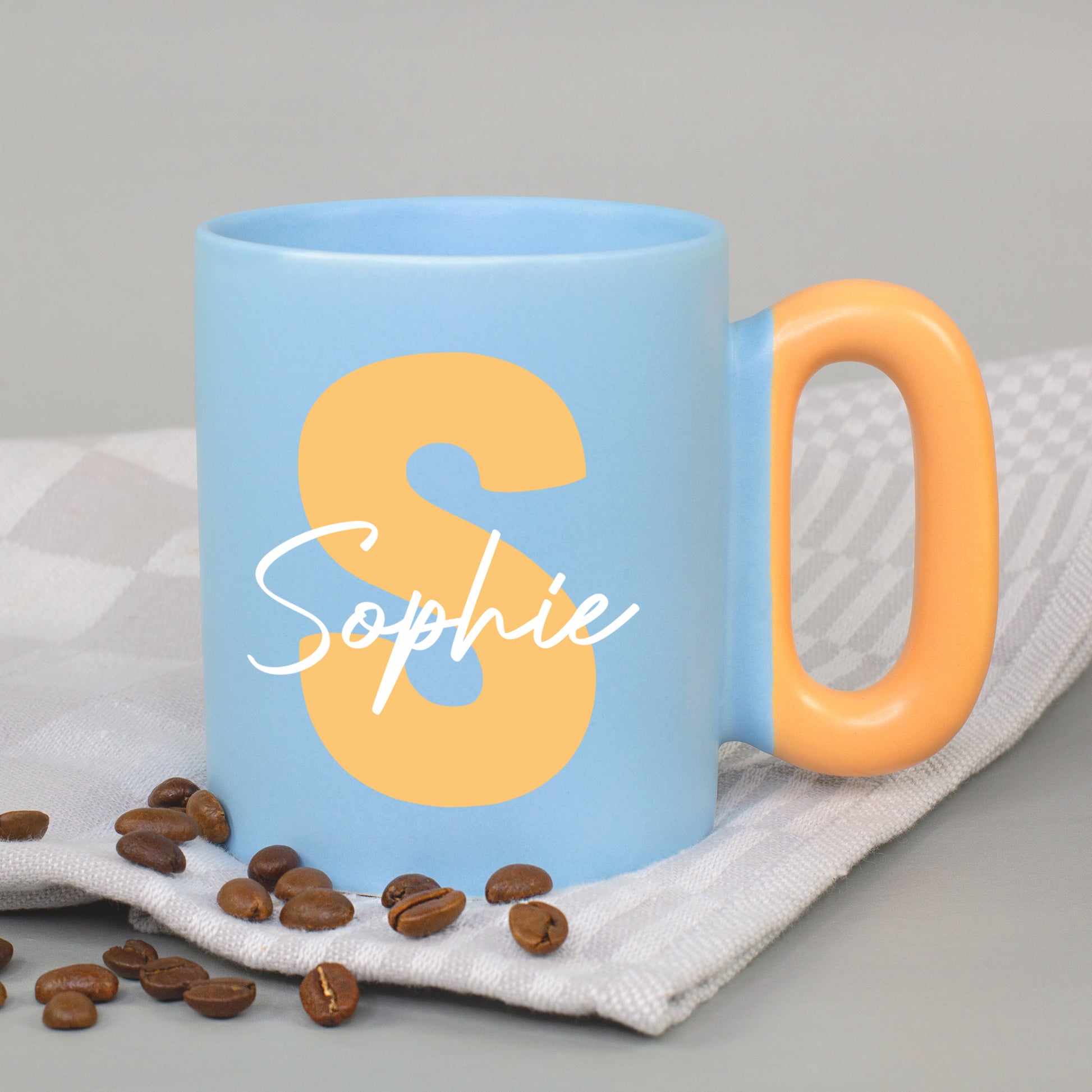 Blaue Tasse mit Initiale S und Name Sophie sowie orangefarbenem Griff