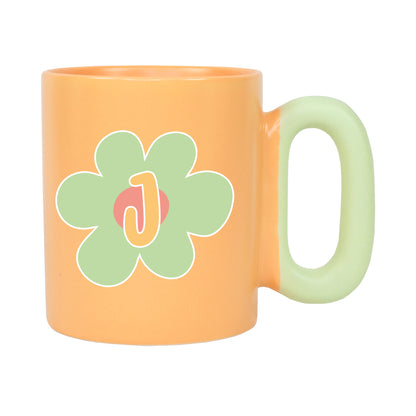 Freigestellte orange Tasse mit Blumenmotiv und Initiale