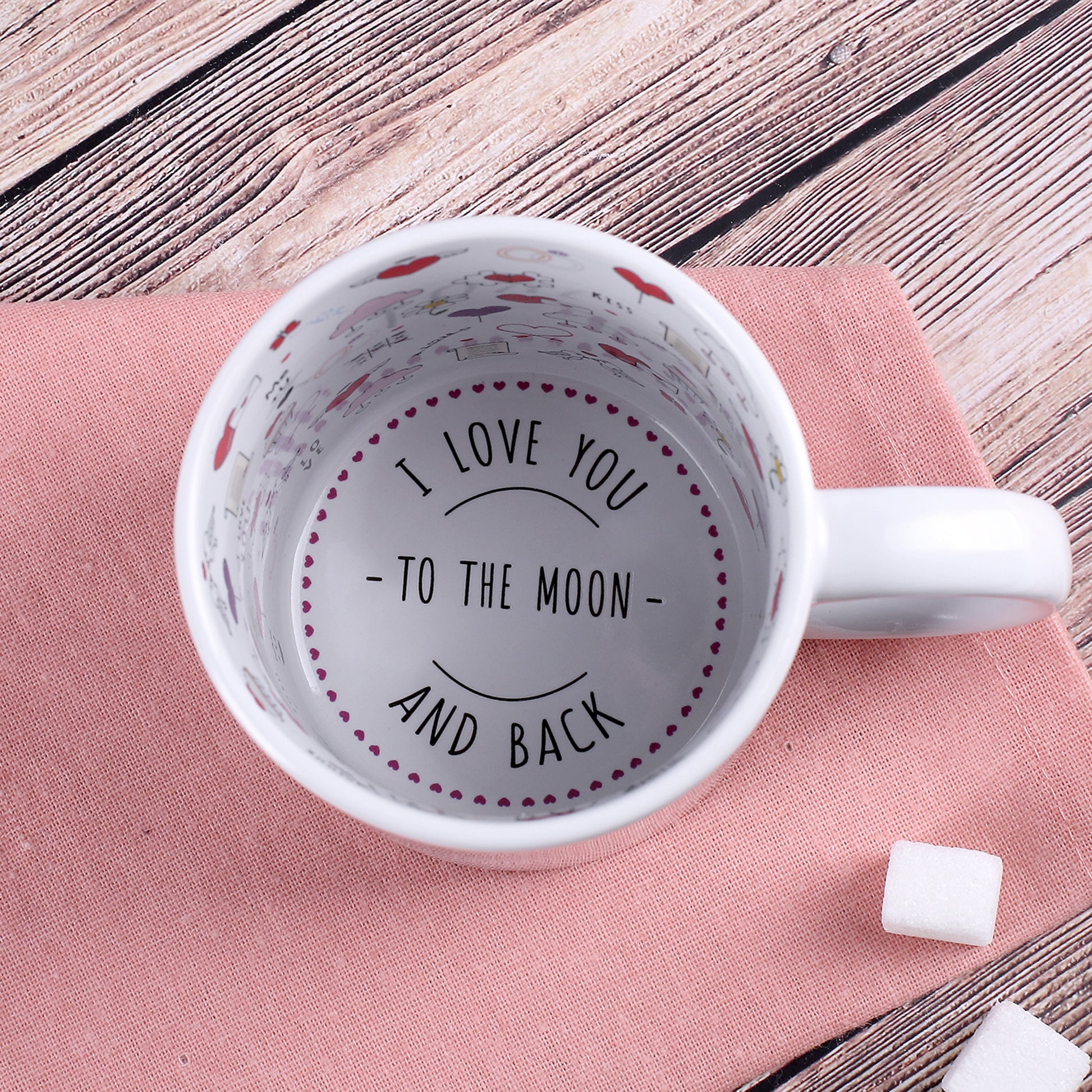 Tasseninnenseite mit romantischen Symbolen und Spruch am Boden „I love you to the moon and back“, Draufsicht