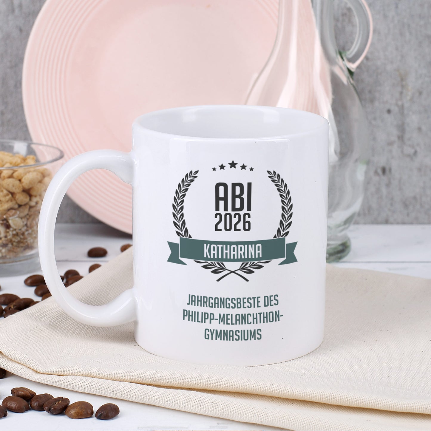 Glückwunsch-Tasse zum Abitur mit Name und Wunschtext dekoriert auf Serviette