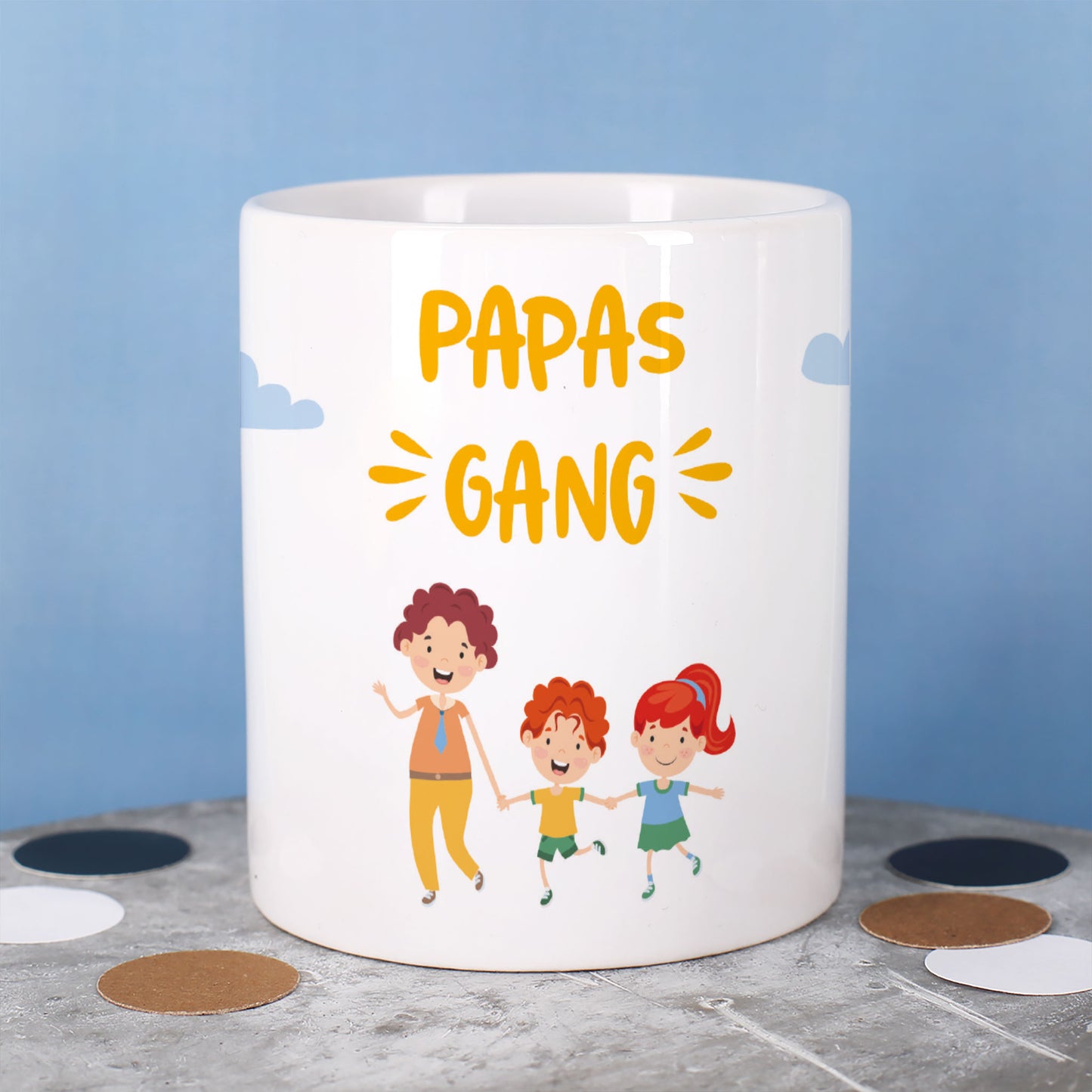 Tasse mit Text „Papas Gang“ und drei Figuren: ein Vater mit zwei Kindern, vor blauem Hintergrund