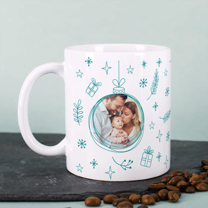 Weihnachtstasse mit grünem Weihnachtskugel-Motiv und Familienfoto, auf dunklem Untergrund mit Kaffeebohnen.
