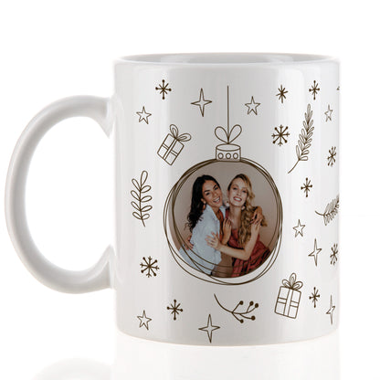 Fototasse mit Weihnachtskugel-Motiv und festlichem Rahmen aus Sternen und Tannenzweigen, Nahaufnahme.