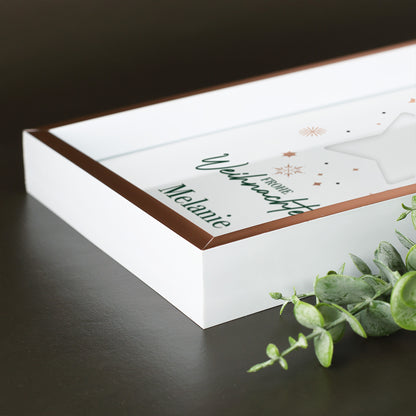 Seitliche Detailaufnahme des roségoldenen Bilderrahmens mit weißem Rand und weihnachtlichem Sternmotiv
