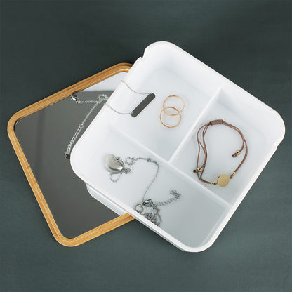 Weißer Schmuckkasten geöffnet, Bambusdeckel mit integriertem Spiegel sichtbar, drei Fächer innen erkennbar.