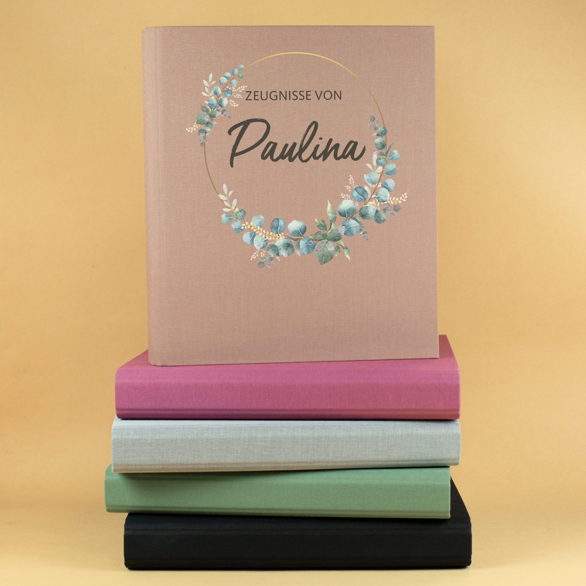 Zeugnismappe aus Leinen mit Eukalyptuskranz, Text Zeugnisse von Paulina, aufgestapelt mit weiteren Farben