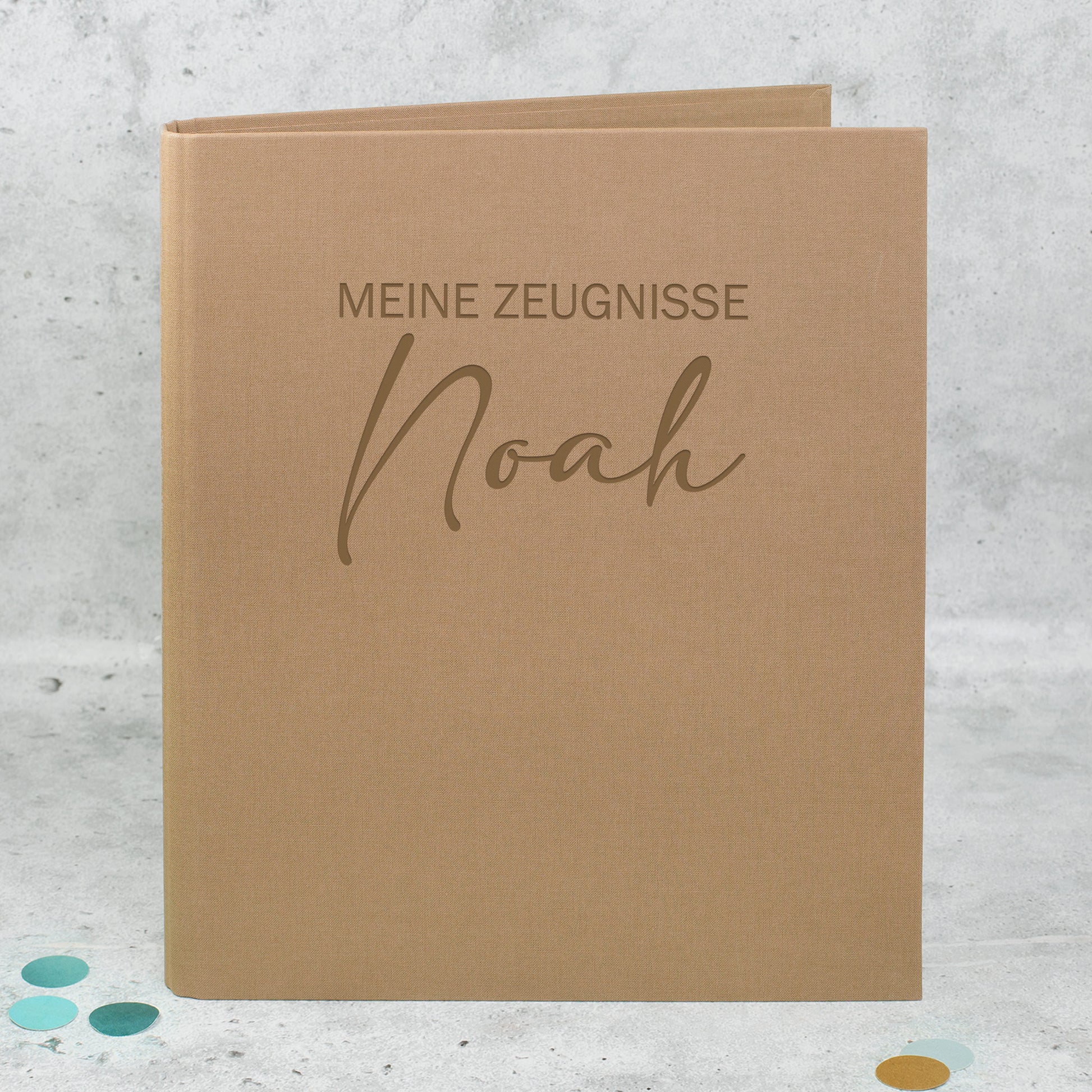 Zeugnismappe aus braunem Leinen mit Gravur „Meine Zeugnisse“ und personalisiertem Namen Noah.