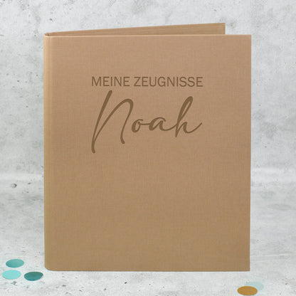 Zeugnismappe aus braunem Leinen mit Gravur „Meine Zeugnisse“ und personalisiertem Namen Noah.
