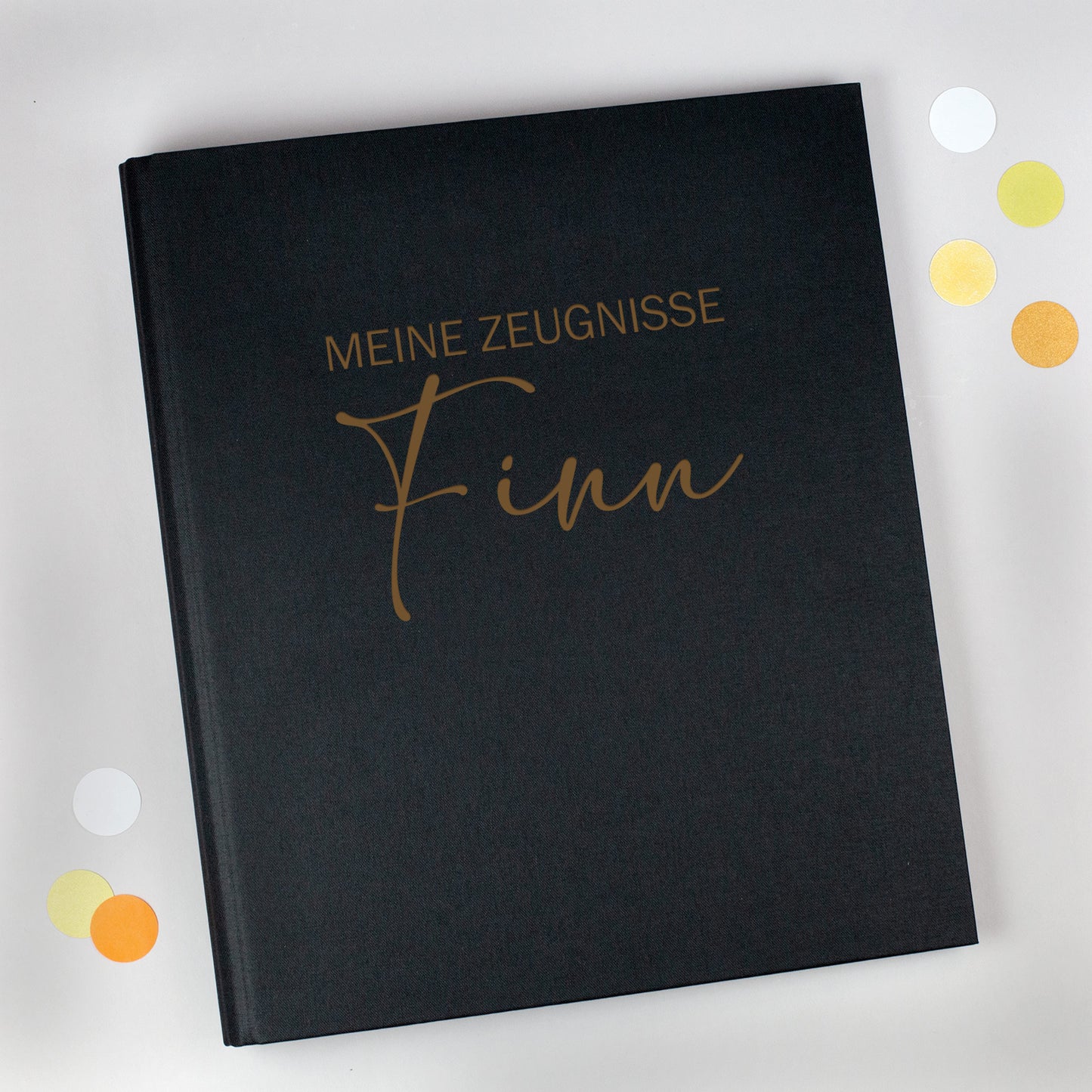 Zeugnismappe aus schwarzem Leinen mit Gravur „Meine Zeugnisse“ und personalisiertem Namen Finn.