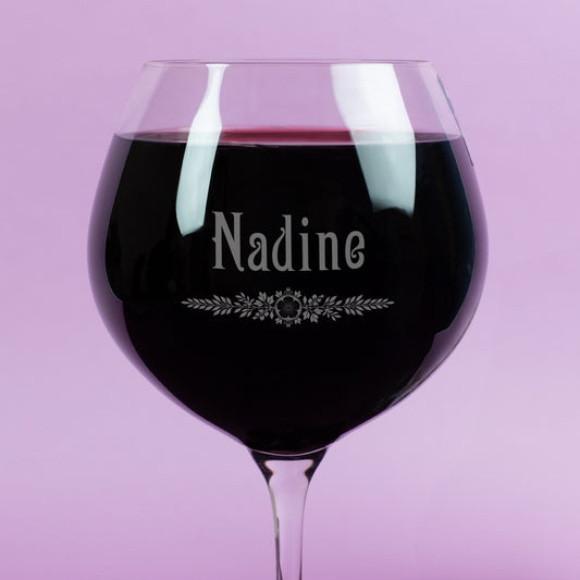 Detailaufnahme des Burgunderglases von Leonardo mit Gravur des Namens Nadine und feinem Blätter-Ornament – hochwertige Gravur im Glas, gefüllt mit Rotwein.