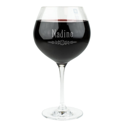 Leonardo Burgunderglas mit Gravur des Namens Nadine und Blatt-Ornament – elegantes personalisiertes Weinglas mit Rotweinfüllung, freigestellt auf weißem Hintergrund.