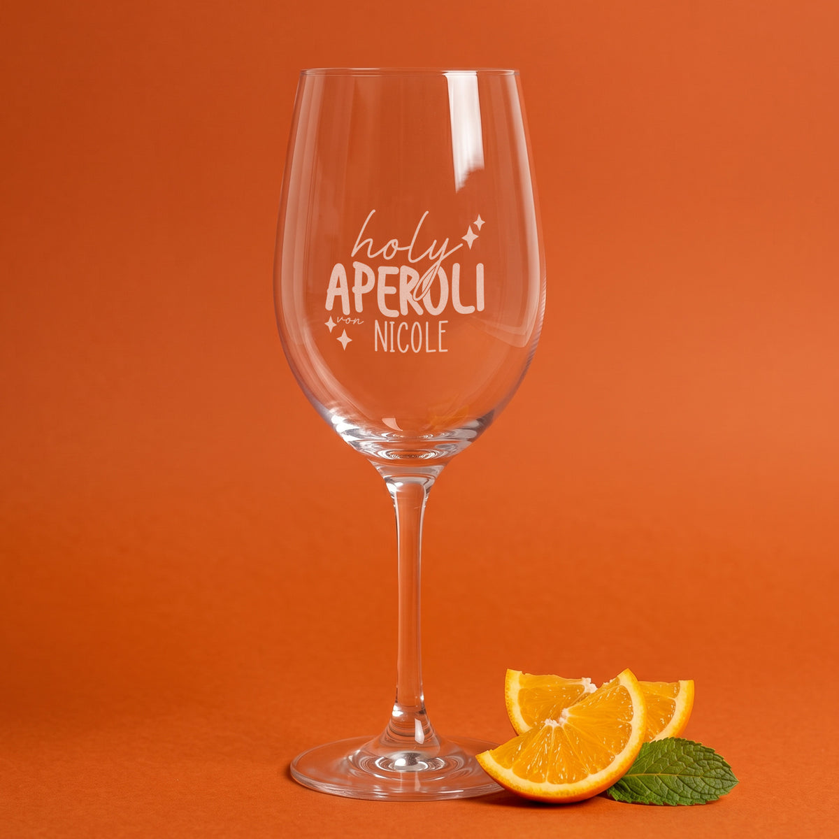 Holy Aperoli Glas von Leonardo mit Namensgravur vor orangefarbenem Hintergrund