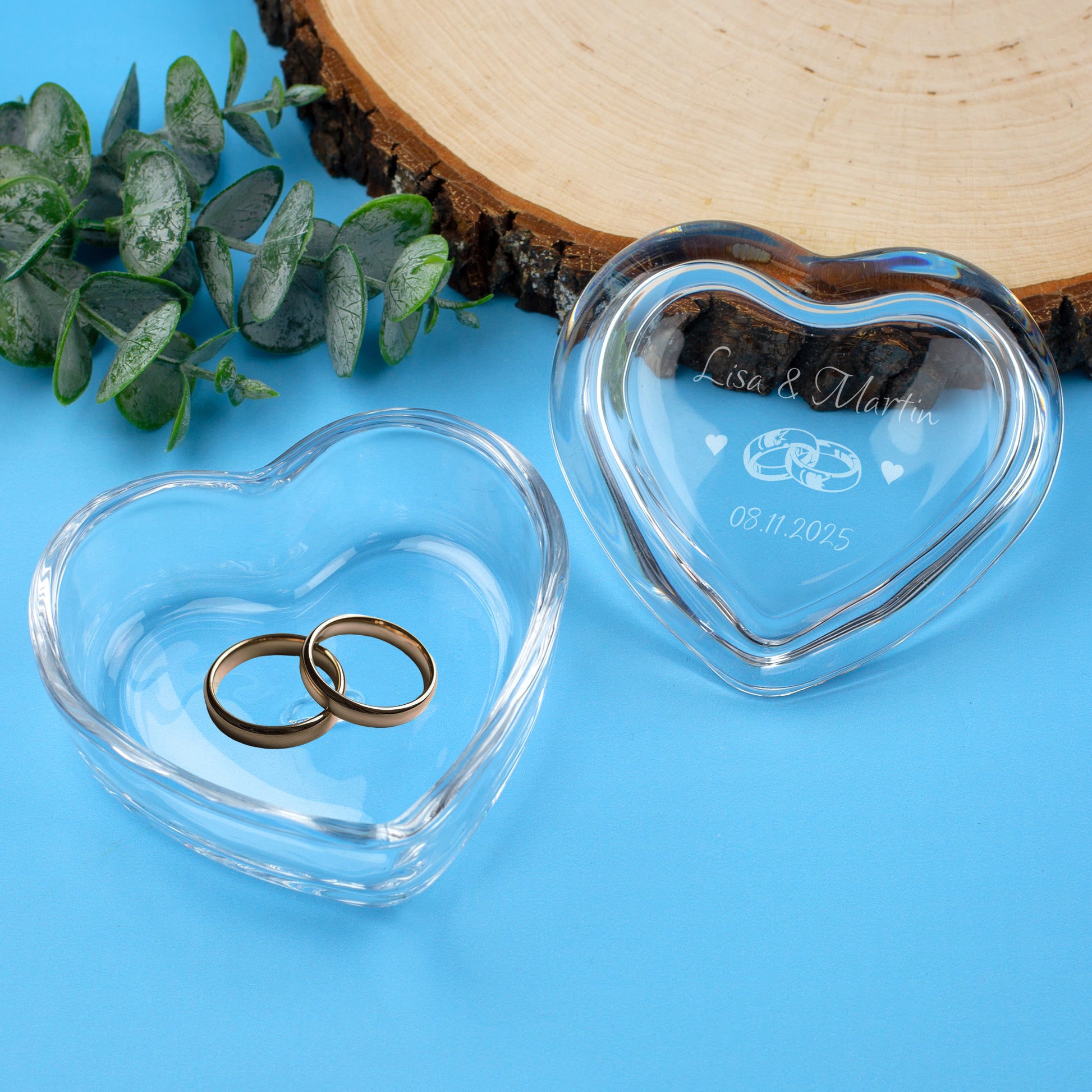 Herzförmige Leonardo Glasdose mit Gravur und Eheringen auf blauem Hintergrund