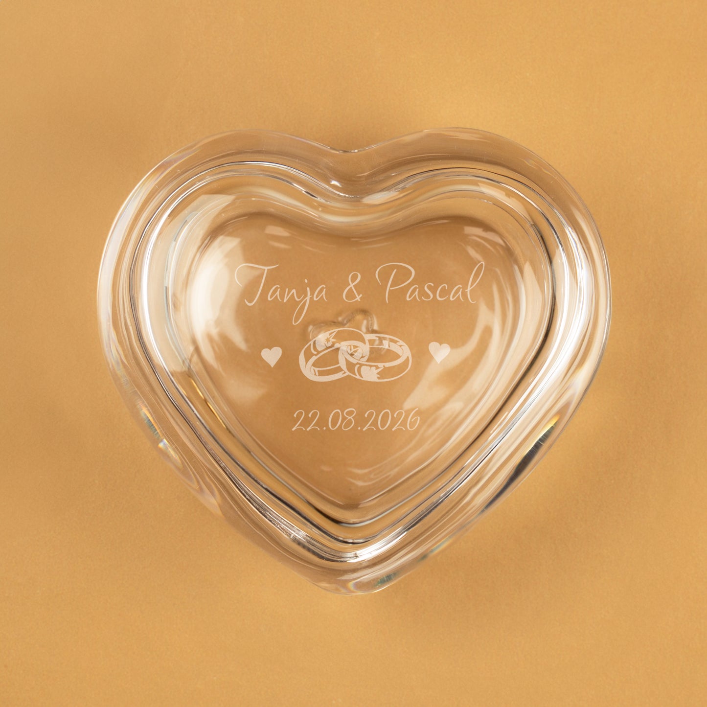 Geschlossene gravierte Herz-Glasdose mit Namen und Datum auf goldenem Hintergrund