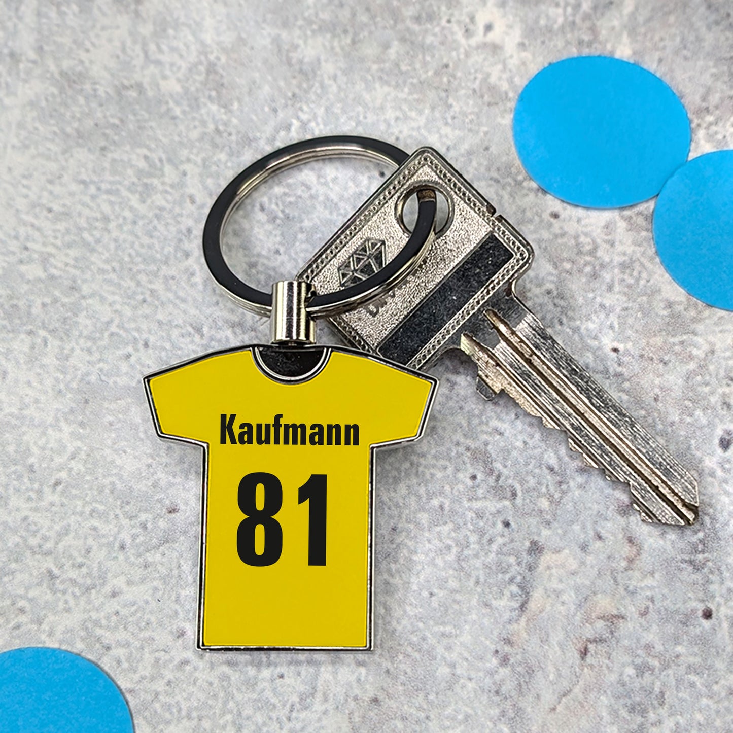 Gelber Trikot-Schlüsselanhänger auf Granitfläche