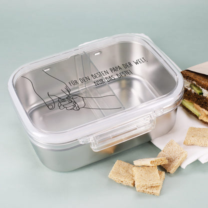 Brotdose mit Hand-Motiv und Aufschrift „Für den besten Papa der Welt“, neben Brotsnack