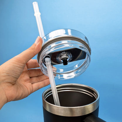 Deckel geöffnet in Hand gehalten mit Strohhalm aus der Nähe