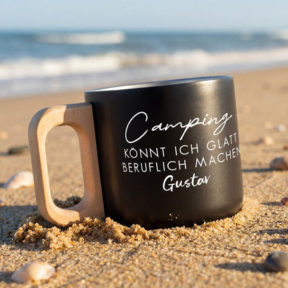 Schwarzer Edelstahlbecher am Strand mit Spruch „Camping könnt ich glatt beruflich machen“ und Name Gustav