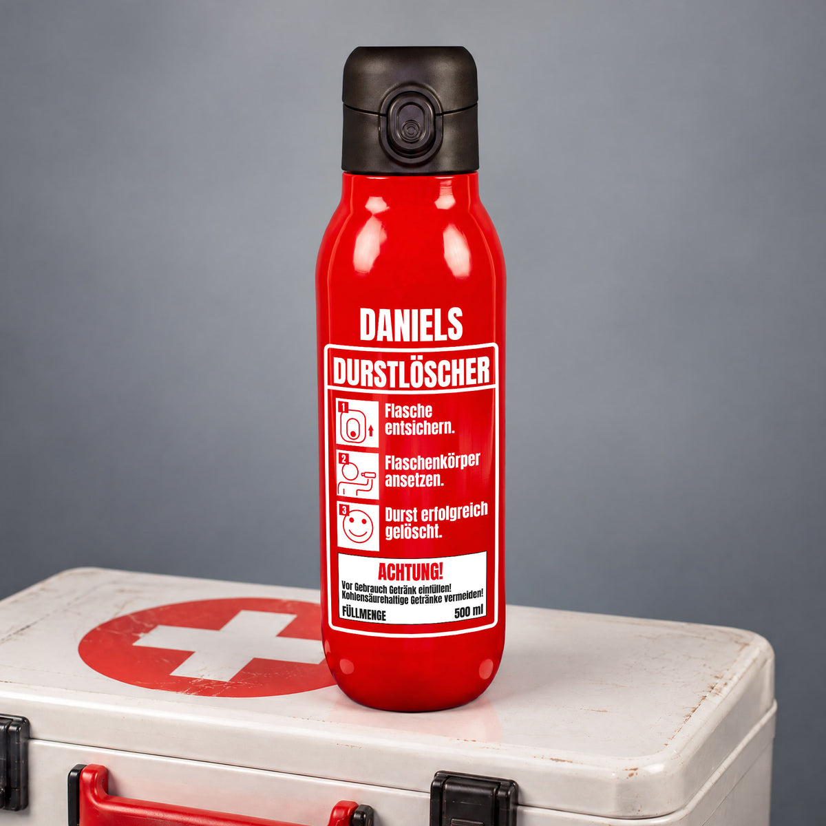 Rote Trinkflasche mit Durstlöscher-Aufdruck und Ihren Wunschnamen auf einen Erste Hilfe Kasten