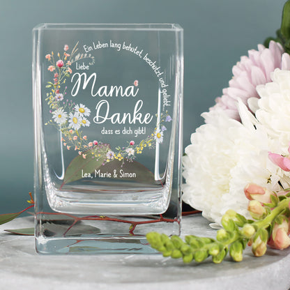Vase mit Blumenmotiv und Aufschrift „Liebe Mama, Danke, dass es dich gibt!“ auf Tisch mit weißen Chrysanthemen, personalisiert mit „Lea, Marie & Simon“