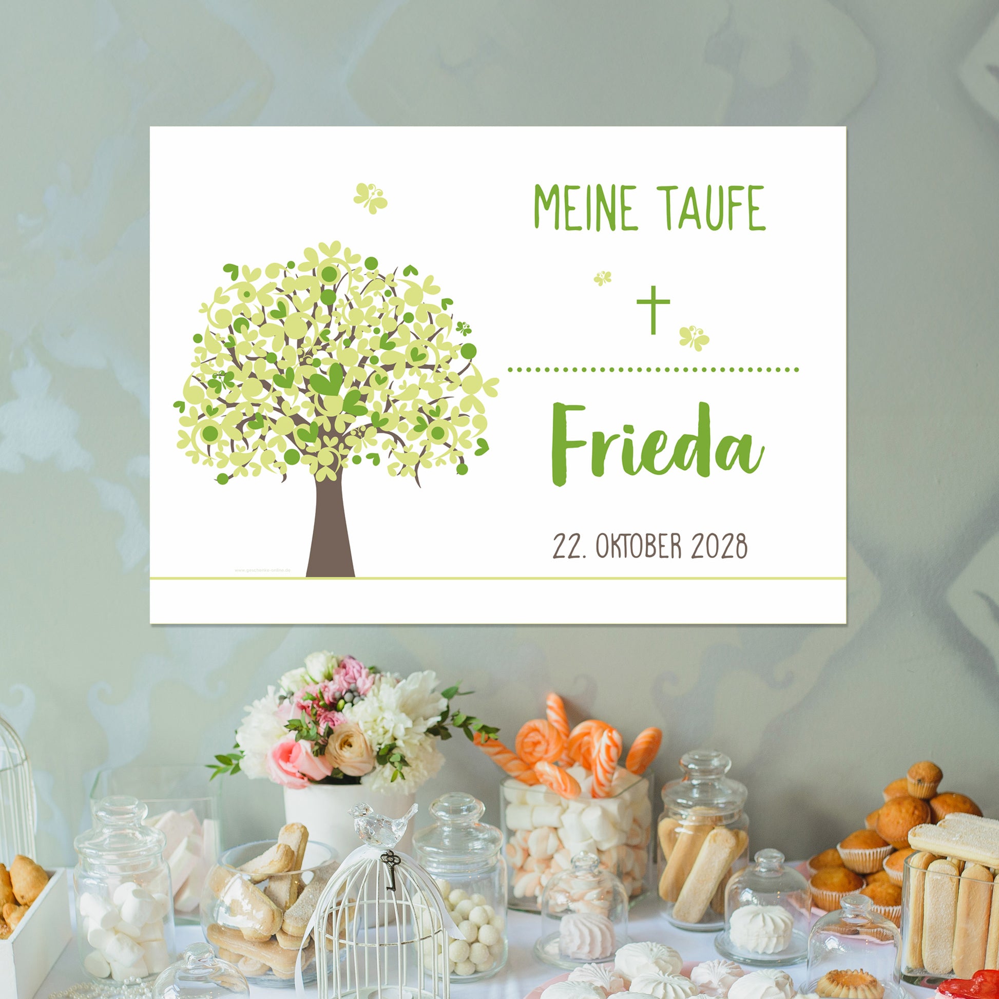 Banner zur Taufe mit grünem Lebensbaum, aufgehängt über einem Sweet Table. Text: „Meine Taufe – Frieda – 22. Oktober 2028“. Frisches Design mit grünen Schmetterlingen und naturfarbenem Baum.