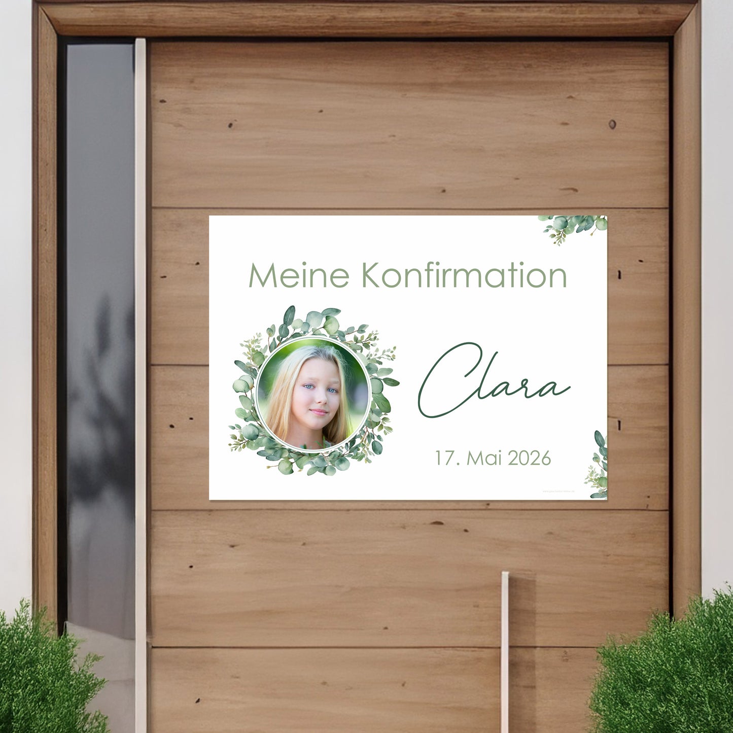 Banner mit Foto eines Mädchens im Eukalyptuskranz an einer Holztür befestigt. Text: „Meine Konfirmation – Clara – 17. Mai 2026“. Feierliche Dekoration für christliche Anlässe.