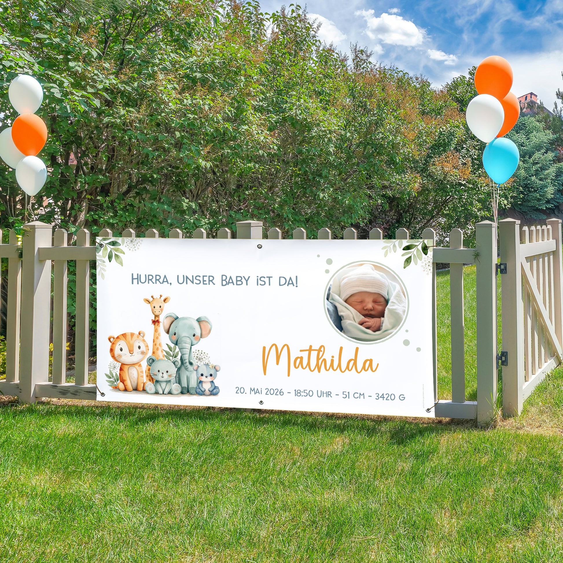 Personalisiertes Banner zur Geburt mit Tiermotiv und Babyfoto am Gartenzaun befestigt