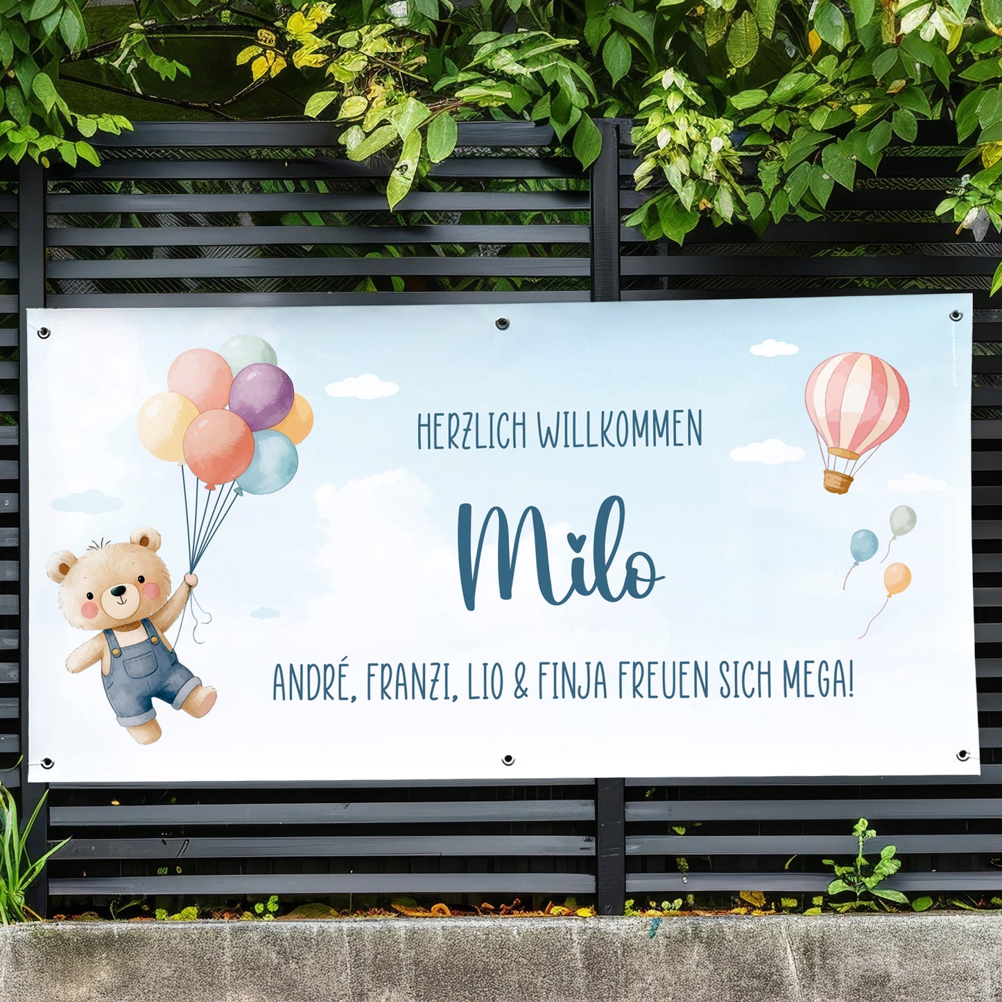 Personalisiertes Banner zur Geburt mit Name Milo und Wunschtext „André, Franzi, Lio & Finja freuen sich mega“ am Gartenzaun