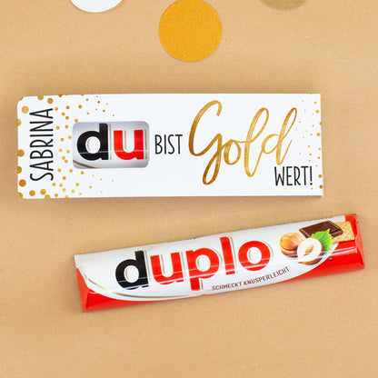 duplo Riegel mit personalisierter Verpackung auf dekoriertem Untergrund mit Konfetti