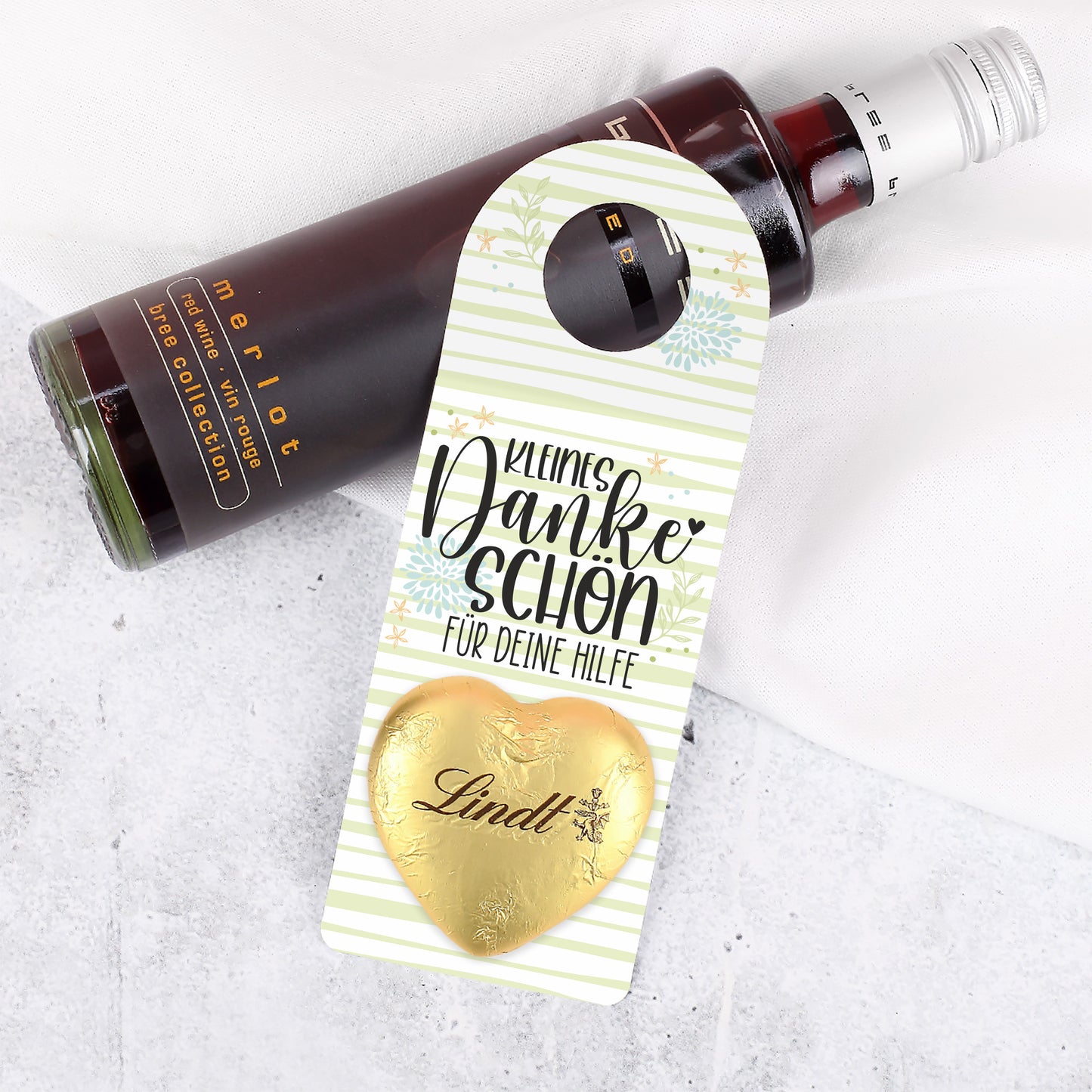 Nahaufnahme des goldenen Lindt Schokoladenherzens auf dem kleinen Flaschenanhänger.