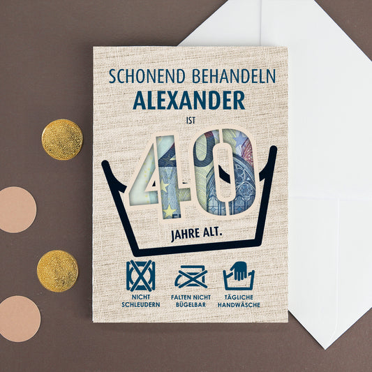 Geldgeschenkkarte „Schonend behandeln – Alexander ist 40 Jahre alt“ mit Euro-Schein, flach liegend neben weißem Umschlag