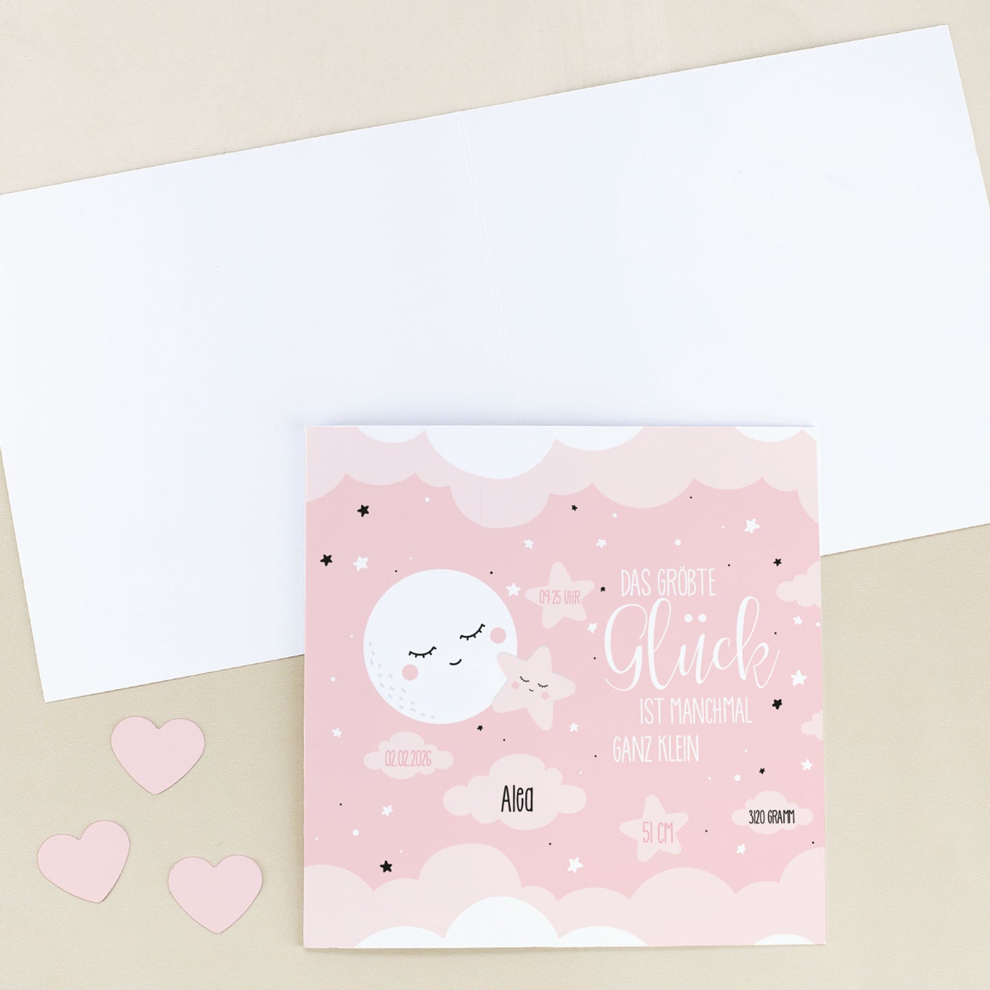 Personalisierte Glückwunschkarte zur Geburt für Mädchen im quadratischen Format mit Umschlag, auf hellem Untergrund fotografiert