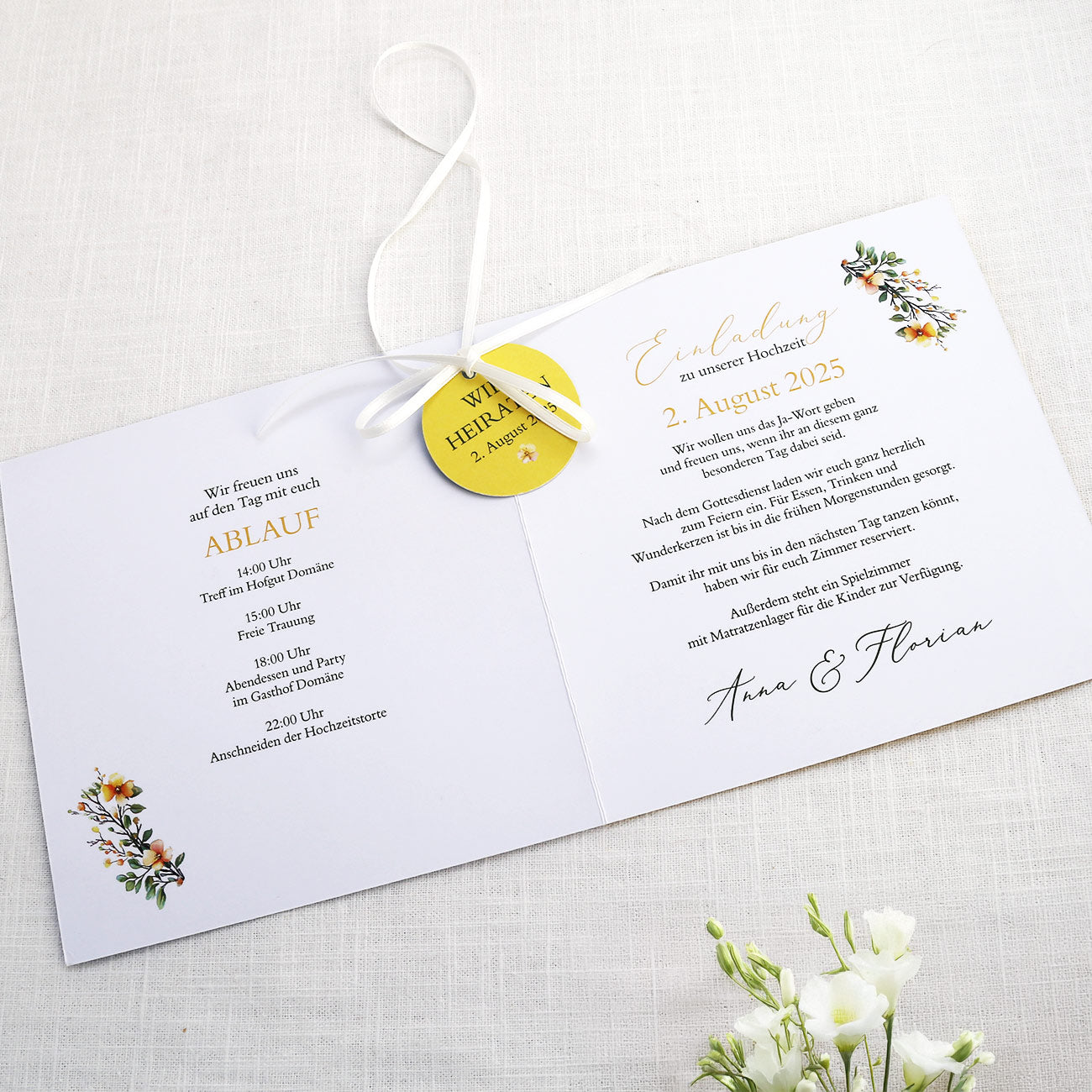 Einladungskarte zur Hochzeit mit Blütenkranz und rundem Anhänger