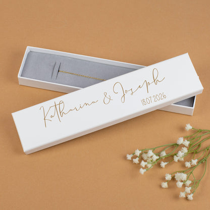 Schmuckschachtel Katharina & Joseph in Goldfarbe, geöffnet auf braunem Hintergrund