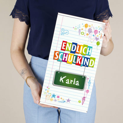 Hoher Geschenkkarton zur Einschulung mit Wunschname, buntem Schulkind-Motiv und den Schriftzug Endlich Schulkind