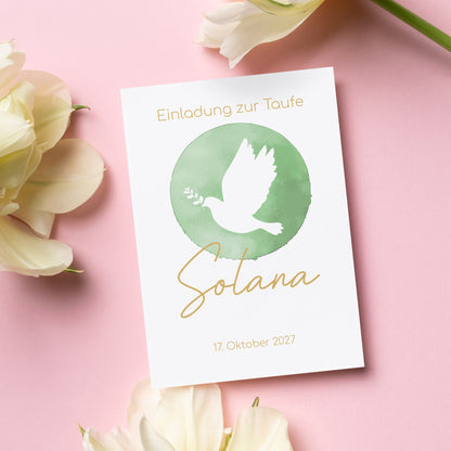 Elegante Einladungskarte zur Taufe mit einem schlichten, modernen Design. In der Mitte befindet sich ein grüner Aquarell-Kreis mit einer weißen Taube, die ein Olivenzweig im Schnabel trägt – ein Symbol für Frieden und Segen. Der Name "Solana" ist in goldener Schreibschrift unter dem Motiv platziert, während darüber der Schriftzug "Einladung zur Taufe" steht. Das Taufdatum, „17. Oktober 2027“, ist am unteren Rand der Karte in einer feinen Schrift gehalten. Die Karte liegt auf einem rosa Hintergrund, umgeben.