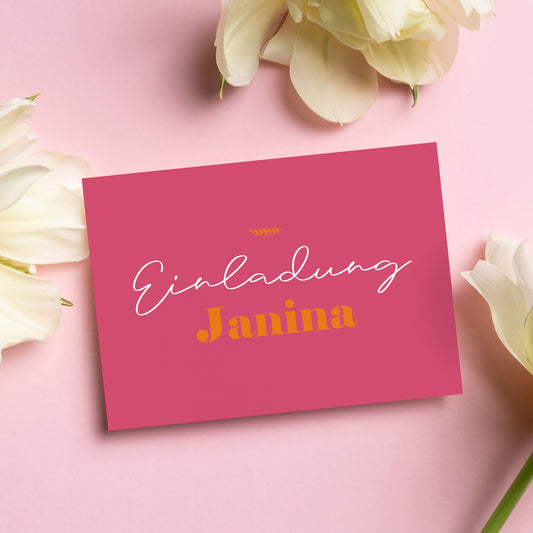 Personalisierte Einladungskarte in kräftigem Rosa mit dem Schriftzug „Einladung Janina“ in eleganter weißer und goldgelber Typografie. Die Karte liegt dekorativ auf einem rosa Hintergrund, umgeben von zarten weißen Blüten. Ideal für verschiedene Anlässe wie Geburtstage, Konfirmationen oder Kommunionen.
