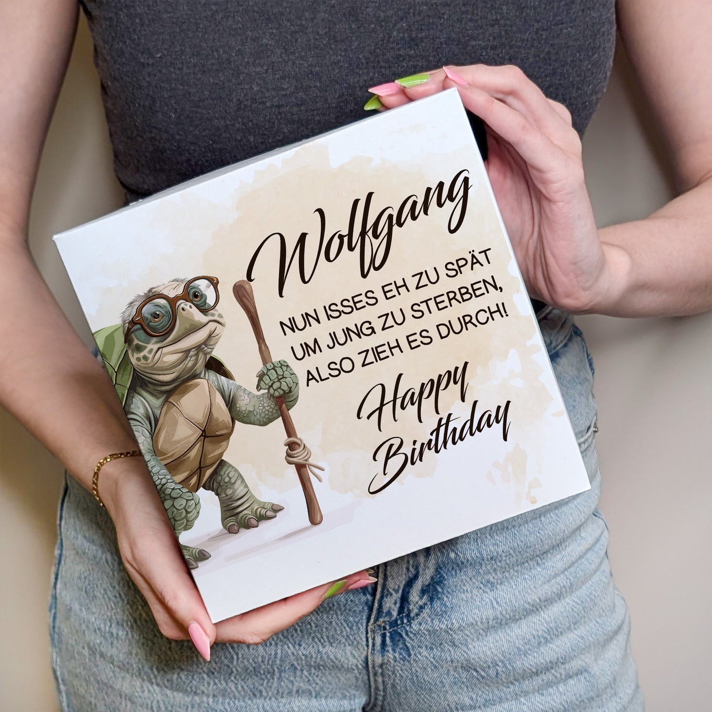 Person hält Kuchenbox mit Schildkrötenmotiv und Namen