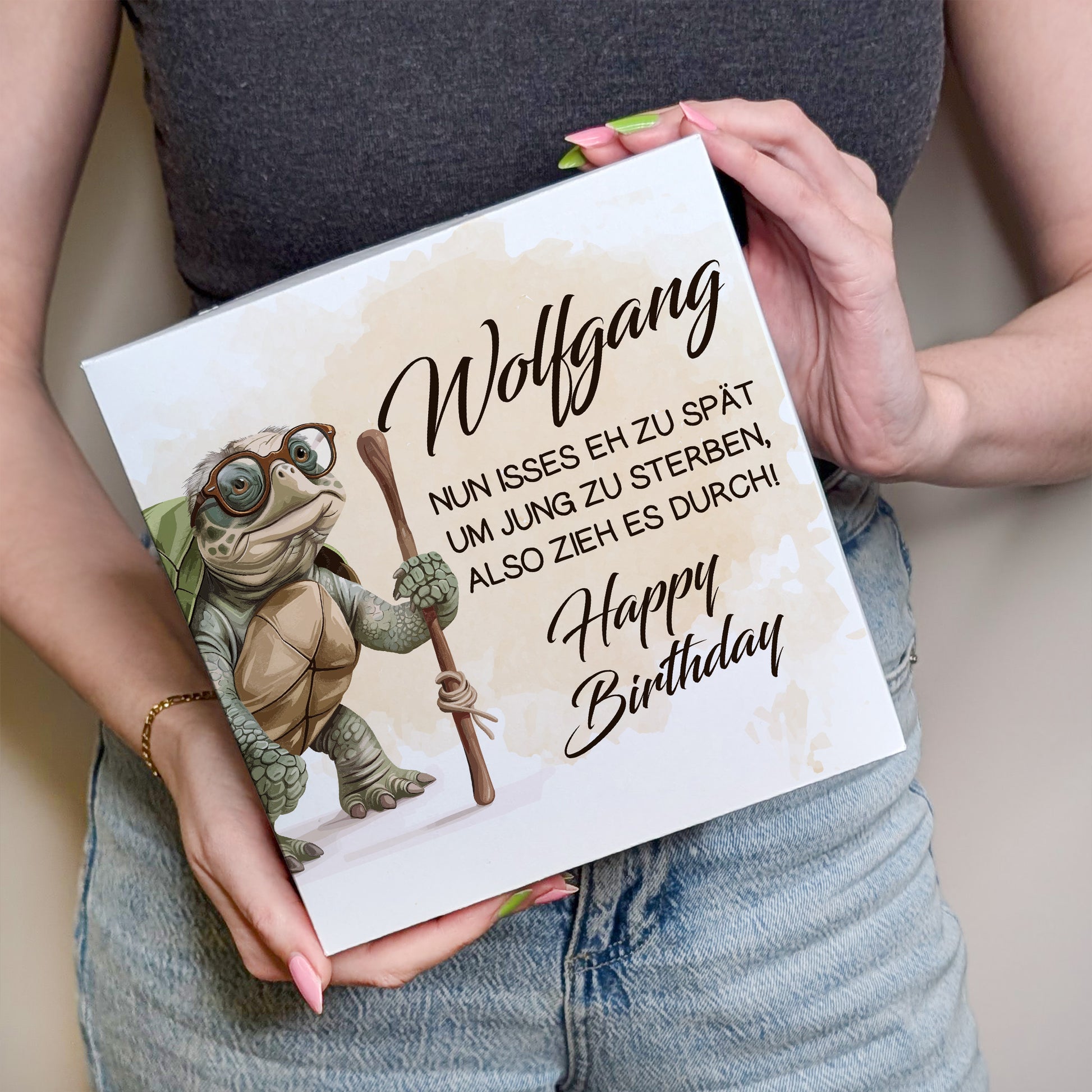 Person hält Kuchenbox mit Schildkrötenmotiv und Namen