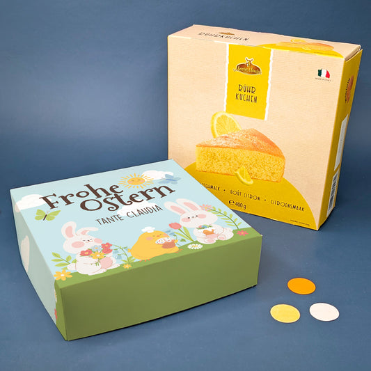 Osterkuchen Geschenkbox mit personalisiertem Namen neben Zitronen Rührkuchen Verpackung