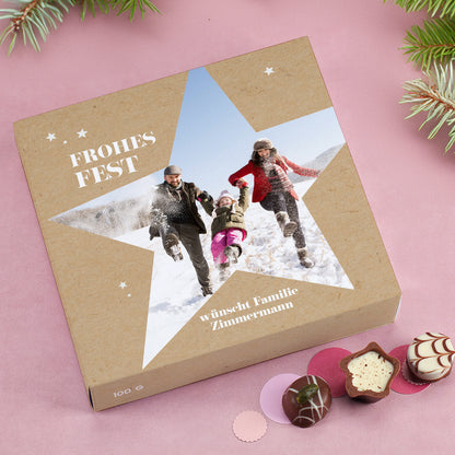 Geöffnete Pralinenbox Frohes Fest mit festlichem Sternmotiv und personalisiertem Foto.