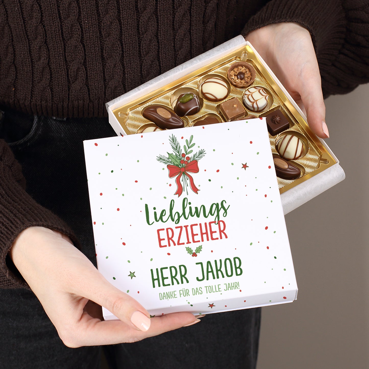 Lindt Pralinenbox mit Weihnachtsmotiv „Lieblingsmensch“, geöffnet in der Hand, individuell bedruckt mit Wunschtext.