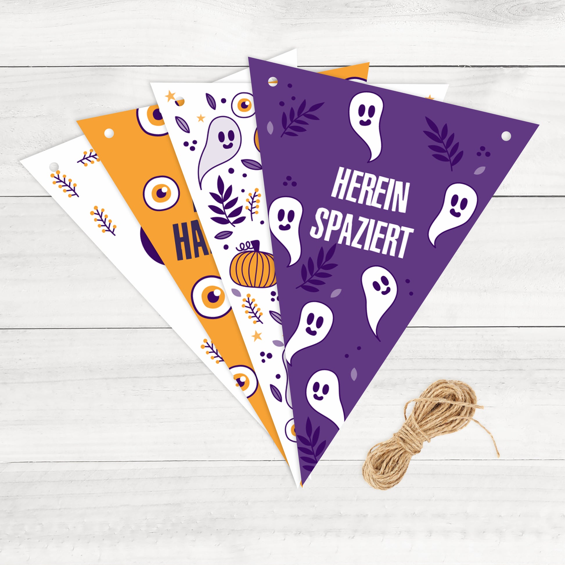 Detailaufnahme der Halloween-Wimpel auf Holzuntergrund – Motiv: Geister und Schriftzug ‚Herein spaziert‘.