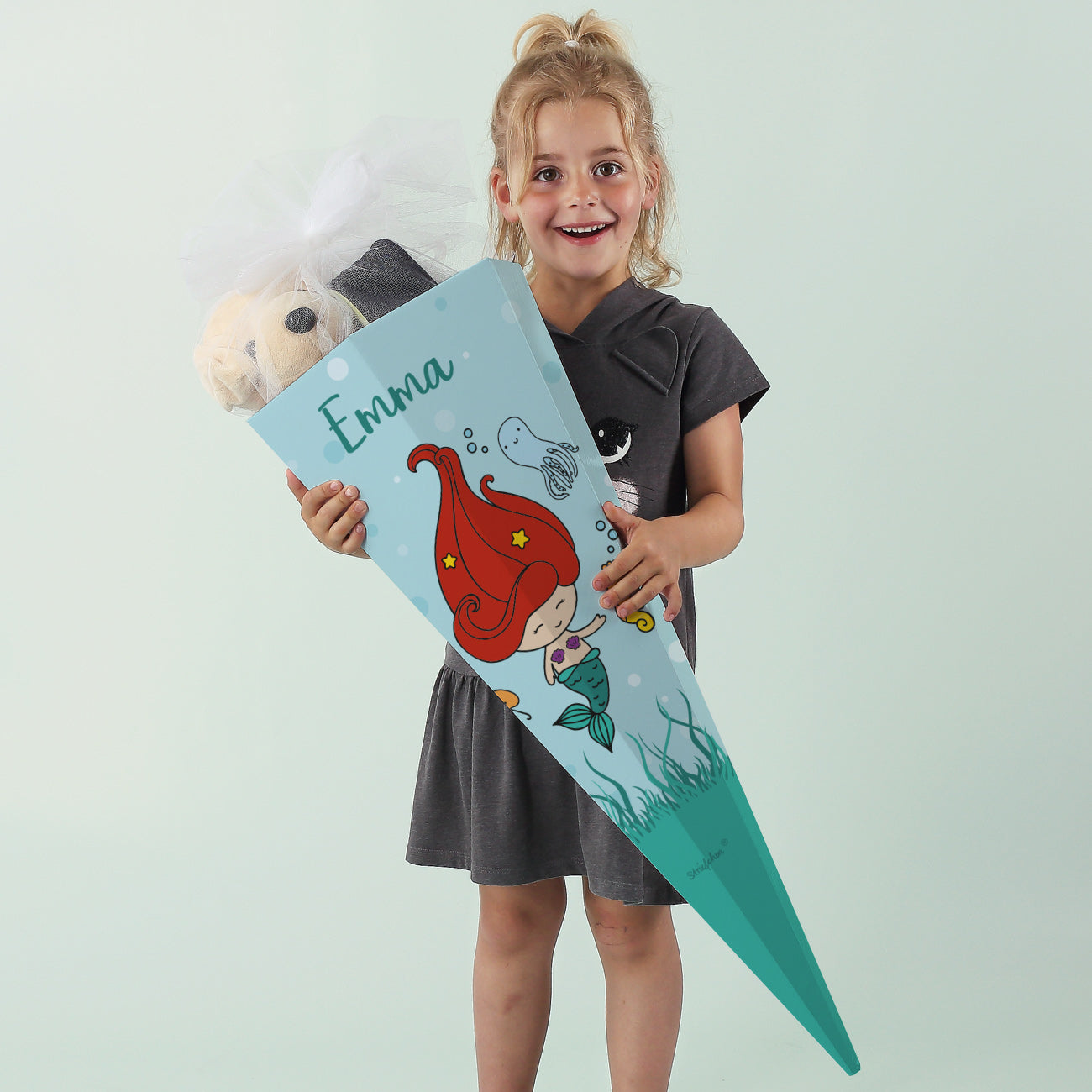 Mädchen zeigt personalisierte Schultüte mit Meerjungfrau und dem Namen Emma