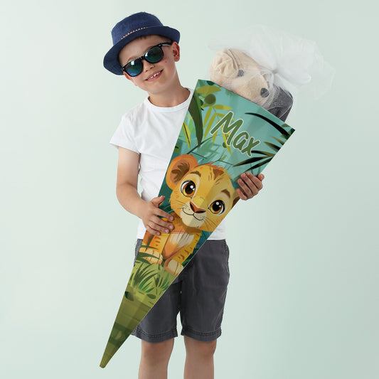 Junge mit Sonnenbrille und Hut lächelt mit einer bunten Schultüte mit Löwenmotiv und Name „Max“.