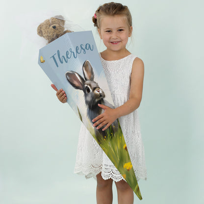 Mädchen mit weißem Kleid und personalisierter Hasen-Schultüte mit dem Namen „Theresa“