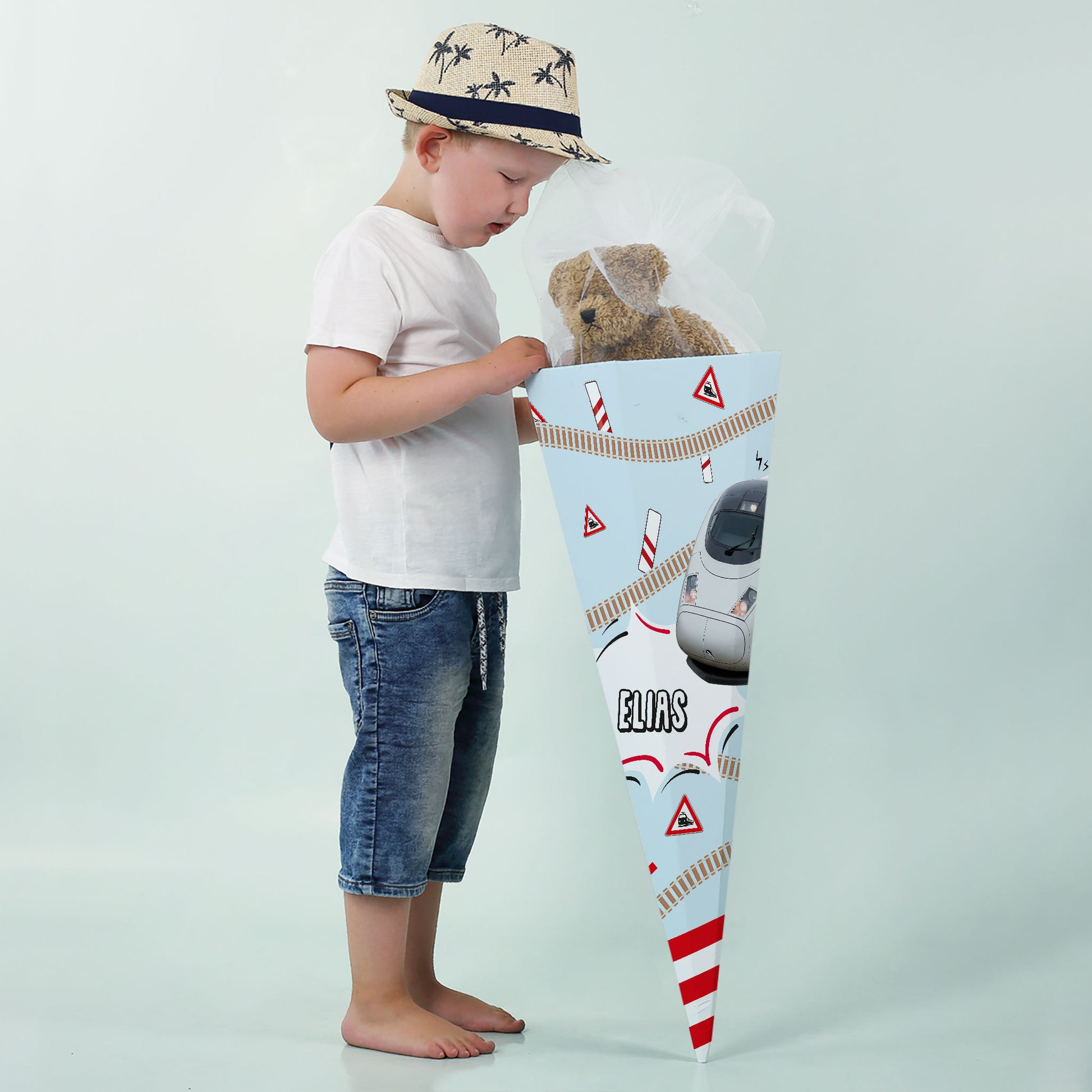 Junge mit großer Schultüte und ICE-Zug-Design